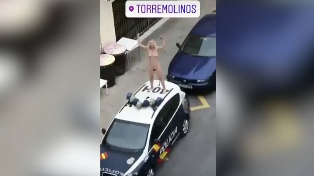 Una mujer desnuda se sube al techo de un coche de policía imagen